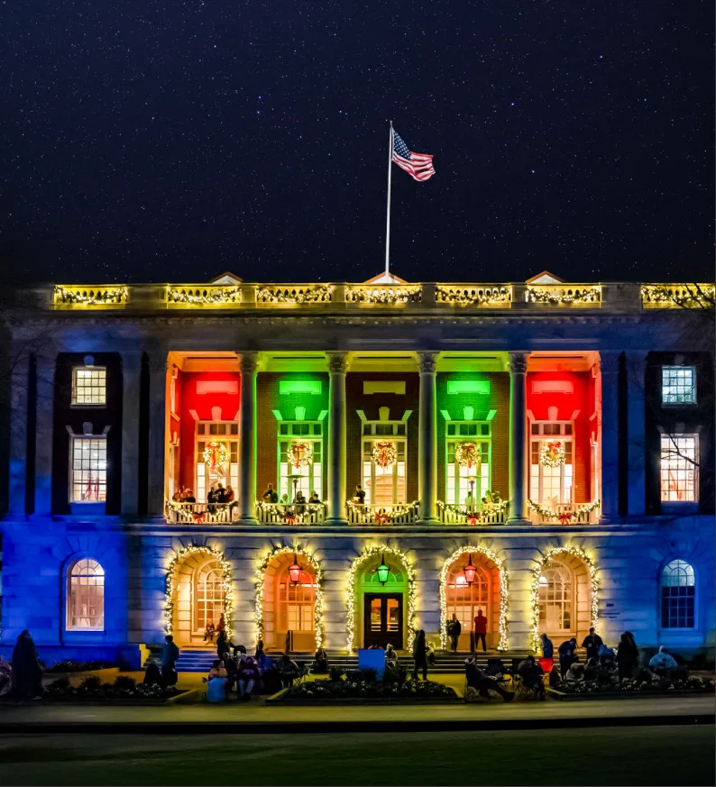 A civic building washed in red and green floodlight